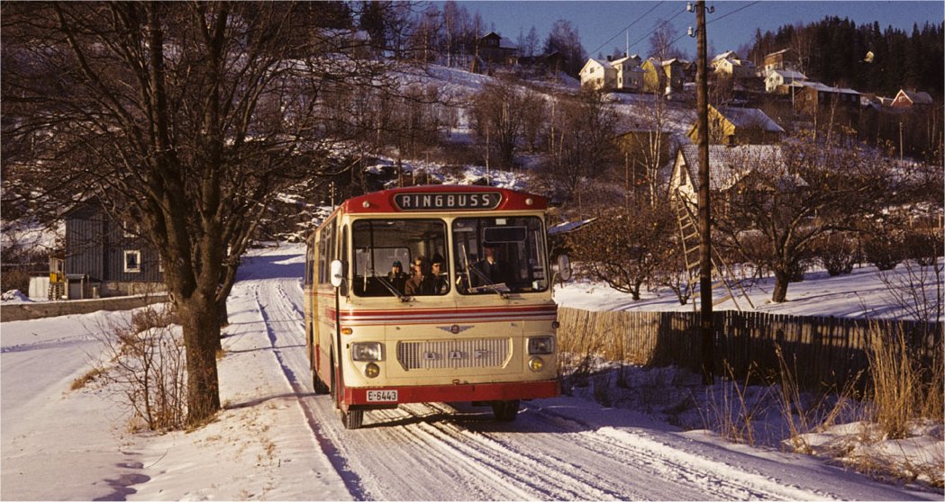 På Lillehammer var Gausdal Bilselskap (GB) og Lillehammer-Ringsaker Bilruter (LRB) begge konsesjonshavere på det området hvor det var bybussrute. De drev i fellesskap en ringbuss fra først på 1950-tallet gjennom selskapet Lillehammer by- og ringbusser. I tillegg drev LRB en rute de kalte "Lokalbussen" i eget konsesjonsområde. Etter hvert trakk GB seg ut av samarbeidet, mens LRB fortsatte med både "Ringbussen" og "Lokalbussen". Fra 15. november 1971 ble det et nytt ruteopplegg hvor GB kom sterkere tilbake med sin "Pendelrute". På bildet ser vi Lillehammer-Ringsaker Bilruters "ringbuss" E-6443, Larvik 1299/1969. DAF SB1600 på Vingnes 14.11.1971. Bildet er tatt siste dag ringbuss-ruten gikk. Bussen var med frem til 1984. LRB kjøpte i stor grad busser med Knudsen-karosseri, men hadde enkelte Larvik-vogner. Bilmerkene varierte mellom Volvo, Scania-Vabis og DAF. Foto Thor Bjerke.