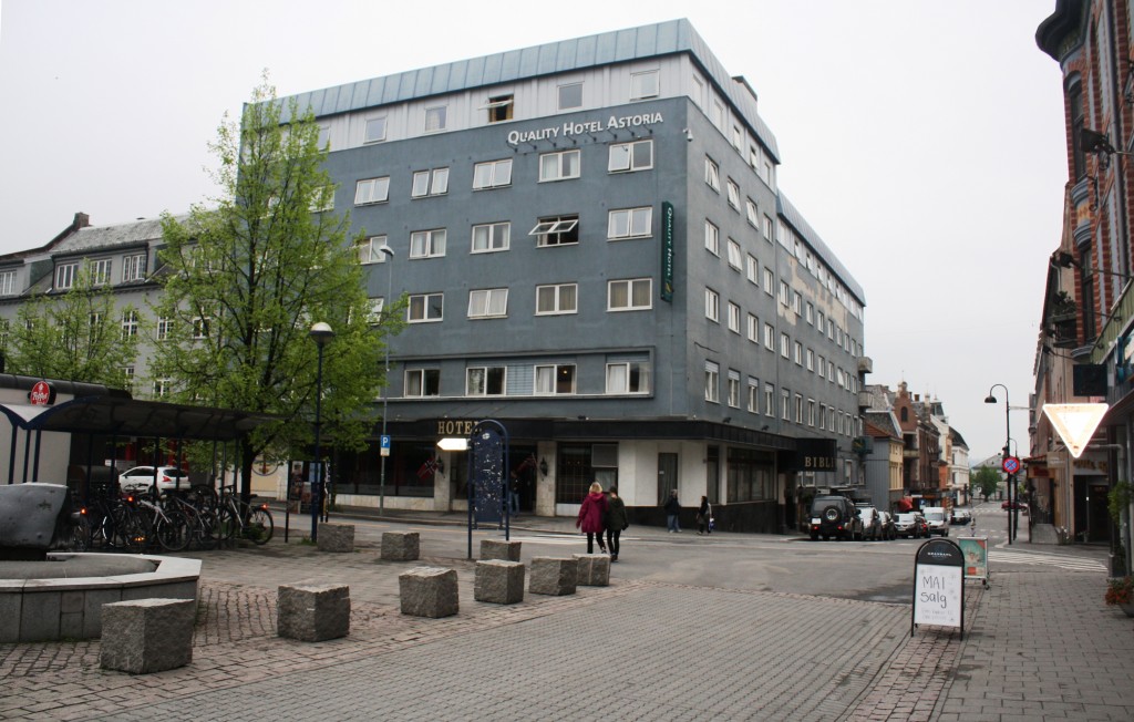 Vi ser Quality Hotel Astoria med Torggata til høyre. I enden av den skimtes jernbanestasjonen. Gata på tvers er Vangsveien med hovedinngangen til Astoria. Til venstre for inngangen på hotellet kan man svinge innom med bussen og sette av passasjerer. Torggata går gjennom hele sentrum, men det meste er gågate. Til venstre på bildet ser vi et hjørne av Østre Torg der rutebilstasjonen i Hamar var helt til 1974.